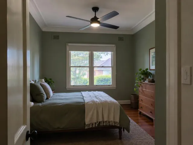 Bedroom with a ceiling fan on a white ceiling above a bed, green walls and window in Georgetown